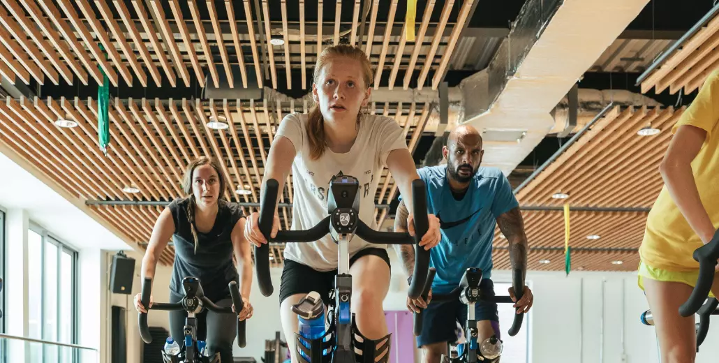 Five customers enjoying a Stages Indoor Cycling class